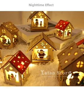 Detail of laser-cut wooden Christmas house ornaments with warm glowing LED lights