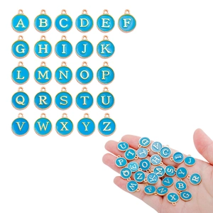 Macro detail of sky blue enamel alphabet charms with gold frames for DIY jewelry making