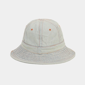 Détail d'un chapeau bob en denim bleu clair avec coutures orange et œillets d'aération