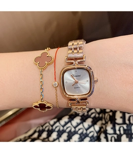 Detail of elegant rose gold square watch with quartz movement worn on a female wrist