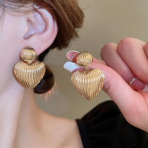 Golden textured heart earrings with vertical striped metallic finish in a retro style