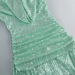 Close-up of mint green sequins and intricate ruched details on a backless evening gown