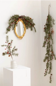 Detail of Christmas pine branch with red berries and pinecones for festive wall decor