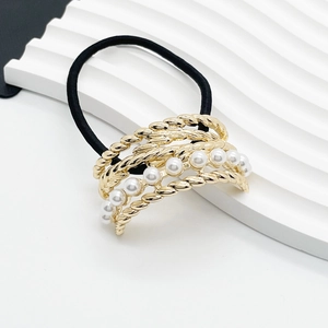 Detailed view of elastic hair tie featuring gold alloy twist decor and faux pearls