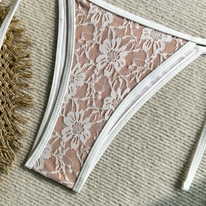 Close-up of white floral lace bikini bottoms with delicate embroidery and smooth seams