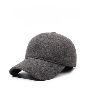 Close-up of wool texture and silver metal brand detail on dark grey winter baseball cap