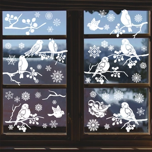 White Christmas window decals featuring birds, berries, and snowflakes on glass