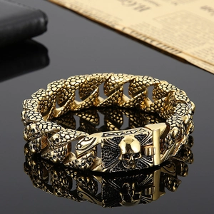 Detailed view of punk style gold skull bracelet with snake scales and cuban link