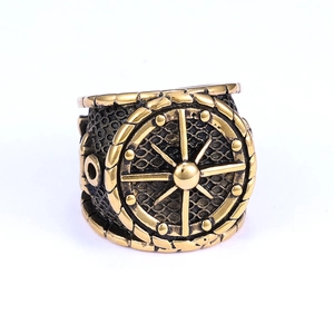 Detail of vintage brass nautical ring featuring anchor and steering wheel engraving