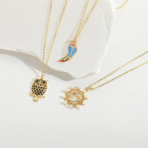 Detailed macro shot of vintage gold heart pendants with enamel bird and owl charms