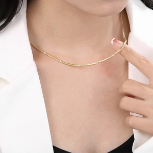 Elegante collana a catena piatta a serpente dorata da 2,2mm indossata da una modella