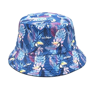 Detail of tropical toucan and monstera leaf print on blue summer bucket hat fabric