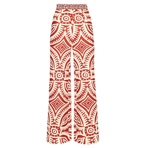 Detail of red and white ethnic geometric pattern on high waist wide leg beach trousers