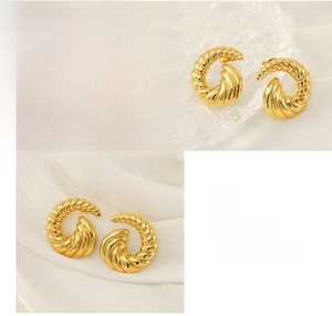 Detailed view of 18k gold plated spiral stud earring with polished metallic texture