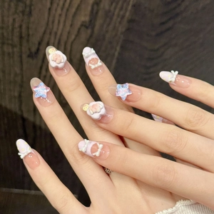 Pink gradient press-on nails with 3D butterflies and cute bear charms on hand