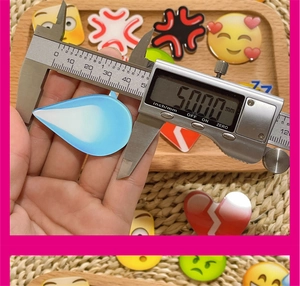 Macro shot measuring 50mm emoji acrylic accessory with a digital caliper tool