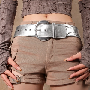 Detail of vintage silver D-ring buckle and double metal eyelets on a wide leather belt
