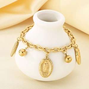 Detailed view of a gold religious bracelet with Virgin Mary medal on a ceramic vase