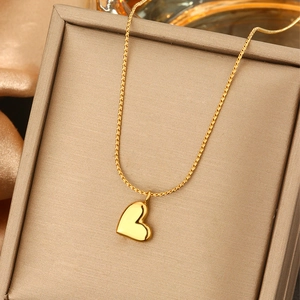 Elegant 18K gold heart necklace on a premium textured jewelry box with silk fabric