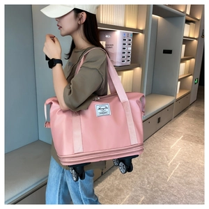 Pink waterproof travel bag with 360-degree swivel wheels shown in hotel setting