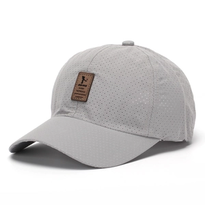 Detail view of grey quick-dry mesh baseball cap with brown faux leather brand patch