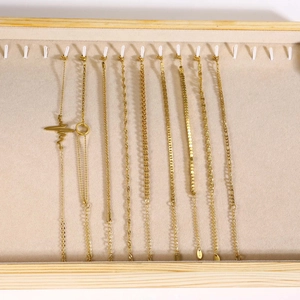 Set of ten 18K gold plated stainless steel bracelets displayed on a velvet jewelry tray