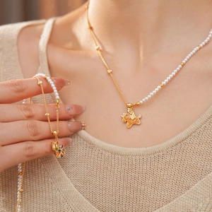Close-up of 18k gold plated unicorn necklace with white pearls and zircon stones