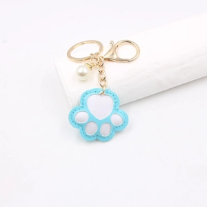 Light blue and white faux leather paw print keychain with gold ring and pearl charm