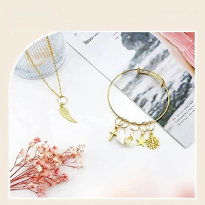 Detail of gold charms including cross, shell and star pendants for DIY hair accessories
