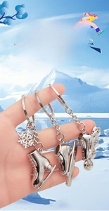 Close-up of metal ice skate and rollerblade keychains featuring polished silver finish