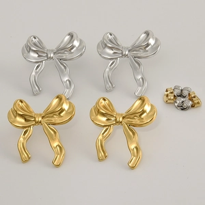 Detailed close-up of bow-shaped stud earrings in gold and silver stainless steel