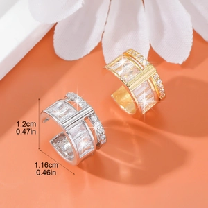 Elegant gold and silver ear cuffs with rectangular zircons on an orange floral background
