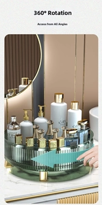 Rotating dark green cosmetic organizer with gold feet on marble countertop