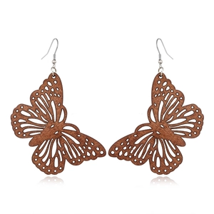 Detailed close-up of butterfly wood earrings with intricate hollow-carved patterns