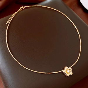 Detailed close-up of a 18k gold plated flower pendant necklace with zircon stone inlay