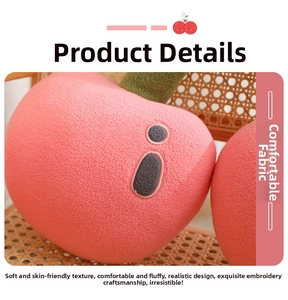 Close-up of pink cherry plush pillow showing soft textured fabric and embroidered face