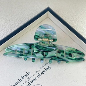 Close-up of a 13.5cm green and grey marble acetate claw clip with a durable metal spring