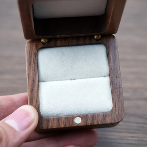 Close-up of walnut wood ring box with soft grey velvet lining and magnetic closure
