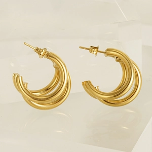Detail of 18K gold-plated multi-layered earrings on acrylic block with butterfly backing