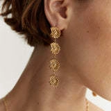 Close-up of 18k gold plated stainless steel triple hoop floral earrings on model
