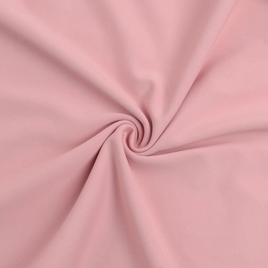 Dettaglio macro del tessuto di pizzo rosa che mostra la texture a spirale e la morbidezza