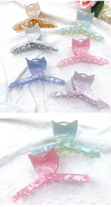 Close-up of mermaid tail hair claws in iridescent acrylic finishes on white fabric