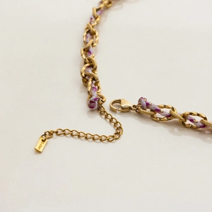 Détail du fermoir mousqueton et de la chaîne d'extension du collier tressé doré