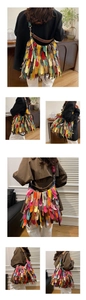 Detail of colorful bohemian fringe shoulder bag with vibrant leather strips and metal buckle
