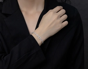 Détail du bracelet en argent sterling serti de zircons sur la manche d'un costume noir