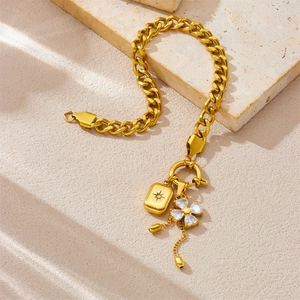 Gold stainless steel Cuban chain bracelet with crystal clover and square lock charms