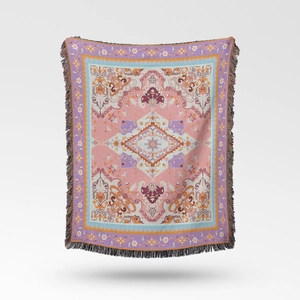 Close-up of bohemian woven throw blanket showing intricate vintage floral patterns and fringe