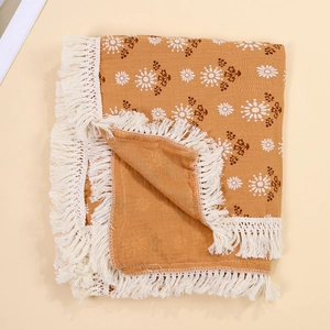 Detail of Muslin baby blanket in amber yellow with white daisy print and elegant fringe edges