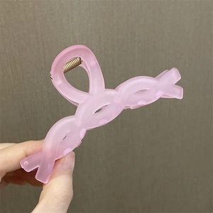 Primer plano de pinza para el pelo con flor rosa mate y mecanismo de resorte metálico