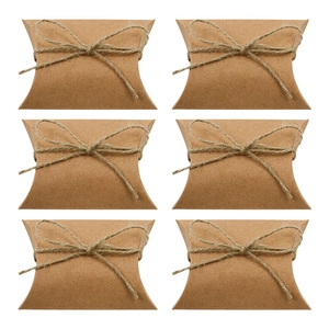 Six kraft paper pillow boxes with twine bows arranged neatly on a white background